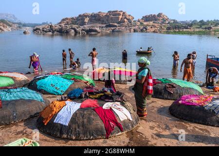 Hampi, Karnataka, Indien - 10. Januar 2020 : Menschen baden und bereiten sich am Ufer des Flusses Tungabhadra in der Stadt Hampi vor. Stockfoto