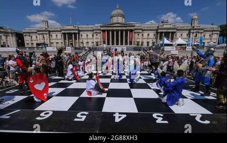 London 18 July 2021 Schachfest auf dem Trafalgar Square, organisiert von der Wohltätigkeitsorganisation Chess in Schools and Communities, deren Aufgabe es ist, die Bildungsergebnisse und die soziale Entwicklung von Kindern zu verbessern, indem sie sie in das Schachspiel einführen. 32 Schauspieler, die als Alice durch die Looking Glass Charaktere gekleidet waren, spielten ein Spiel basierend auf dem Buch in einem riesigen Schachbrett. Paul Quezada-Neiman/Alamy Live News Stockfoto