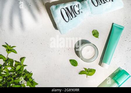 Gläser kosmetische Creme mit grünen Blättern, omg Haarband der Minzfarbe auf weiß mit Schatten, Oberkante Stockfoto