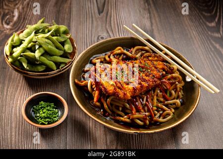 japanische Nudeln mit knusprigem Huhn und Edamame Stockfoto