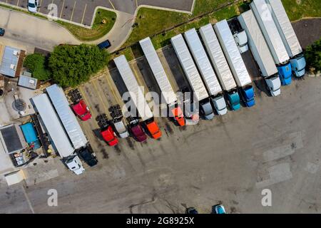 Rastplatz mit verschiedenen Arten von Lastwagen auf einem überfüllten Parkplatz in der Nähe der Autobahn Stockfoto