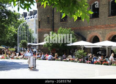 Essen im Freien im Restaurant des Deutschen Gymnasiums, am Battle Bridge Place hinter der Kings Cross Station im Norden Londons, Großbritannien Stockfoto