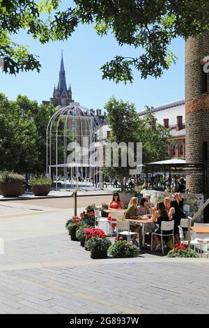 Essen im Freien im Restaurant des Deutschen Gymnasiums, am Battle Bridge Place hinter der Kings Cross Station im Norden Londons, Großbritannien Stockfoto