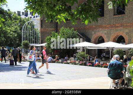 Essen im Freien im Restaurant des Deutschen Gymnasiums, am Battle Bridge Place hinter der Kings Cross Station im Norden Londons, Großbritannien Stockfoto