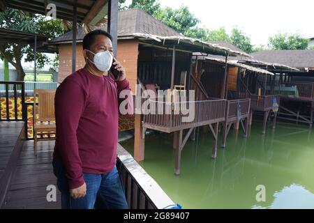 Ein Mann, der eine Maske trägt, telefoniert Stockfoto