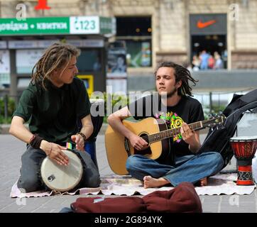 Straßenmusiker, zwei Jungen mit Bongo-Schlagzeug und Gitarre, die auf einer Straße Musik spielen. 5. Juni 2019. Kiew, Ukraine Stockfoto