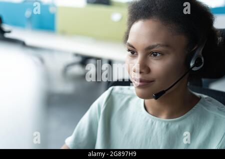 Wie kann ich Ihnen helfen? Im modernen Büro arbeiten wunderschöne Callcenter-Mitarbeiter mit Kopfhörern Stockfoto