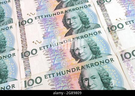 Ein Hintergrund der schwedischen 100 Kronen-Währungsscheine, die in einem Raster angeordnet sind. Stockfoto