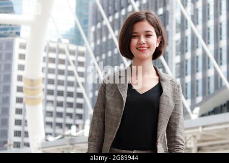 Porträt von jungen und schönen niedlichen Geschäftsfrau Halbrennen Thai-deutsche tragen Business-Anzug stehen und lächeln Blick auf die Kamera mit selbstvertrauten Stockfoto