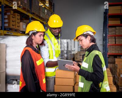 Ein Team von Lagerarbeitern steht vor der Inspektion der Fertigwaren für die Auslieferung an Kunden im Vorbereitungsbereich für die Lieferung innerhalb der Lagerhalle Stockfoto