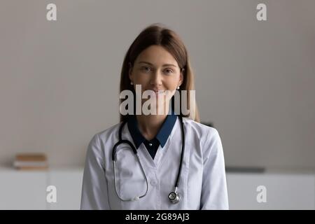 Glückliche junge Ärztin, die die Kamera anschaut Stockfoto