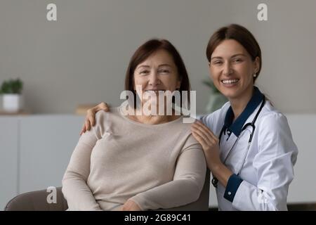 Glücklicher Arzt und dankbarer leitender Patient lächeln der Kamera zu Stockfoto