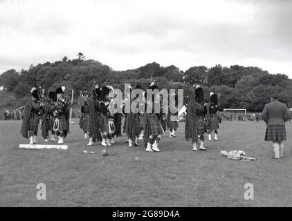 1956, historisch, bei einem Hochland-Spiel, spielt eine Hochland-Band draußen auf einem Feld. Stockfoto