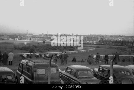 1960er Jahre, historisch, Blick über einige geparkte Autos von Zuschauern bei einem Pferderennen meetng, England, Großbritannien. Stockfoto