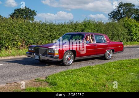 1983 80s rotes Fleetwood Cadillac Fahrzeug der Achtziger Jahre auf dem Weg zur Capesthorne Hall Oldtimer-Ausstellung im Juli, Cheshire, Großbritannien Stockfoto