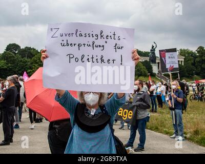 Demosntrantin hält ein Schild mit der Aufschrift: ' Verlässlichkeitsprüfung für Politiker! Laut Veranstalter*innen sammeln sich am 18. Juli 2021 auf der Theresienwiese in München 2500 Menschen, um gegen die Novelle des bayerischen Polizeiaufgabenetzes zu demontieren. Das NoPAG Bündnis critisiert die weiteren Verschärfungen wie die Verlässigkeitschonung bei Versammlungen und warnt vor einem Politbüro Bayern. * Protestor hält Schild mit der Aufschrift: "Zuverlässigkeitsprüfung für Politiker! Wie die Organisatoren mitteilten, nahmen 2500 Menschen an einer Kundgebung gegen die Änderung des Bayerischen Teil Stockfoto