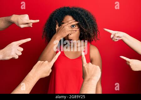 Schöne afroamerikanische Frau mit afrohaarigen Fingern, die auf sich zeigen und in schockbedeckendes Gesicht und Augen mit der Hand blicken, die thr Stockfoto