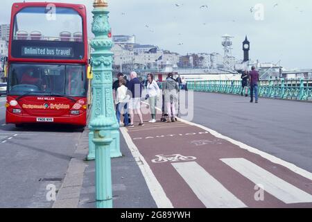 Farbenfrohe Doppeldecker-Reisebusse warten an den Bushaltestellen, um Passagiere für ihre Fahrten entlang der Küste von Brighton nach Eastbourne abzuholen Stockfoto