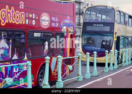 Farbenfrohe Doppeldecker-Reisebusse warten an den Bushaltestellen, um Passagiere für ihre Fahrten entlang der Küste von Brighton nach Eastbourne abzuholen Stockfoto