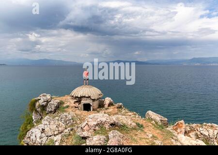 Junge, der auf einem alten Bunker am Ohridsee in der Nähe von Lin, Region Korca, Albanien, steht Stockfoto