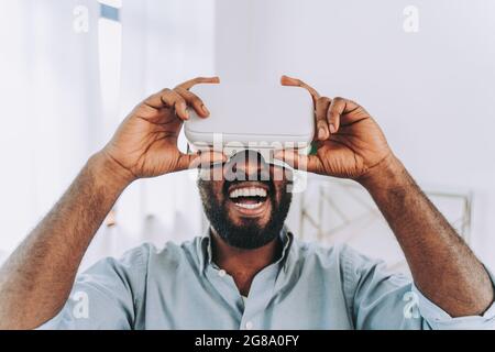 Schöner schwarzer Erwachsener zu Hause, der mit vr-Headset spielt Stockfoto