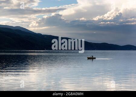 Fischer und ein kleines Mädchen in einem traditionellen Fischerboot auf dem Ohrid See, Lin, Albanien Stockfoto