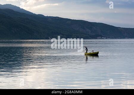 Fischer und ein kleines Mädchen in einem traditionellen Fischerboot auf dem Ohrid See, Lin, Albanien Stockfoto