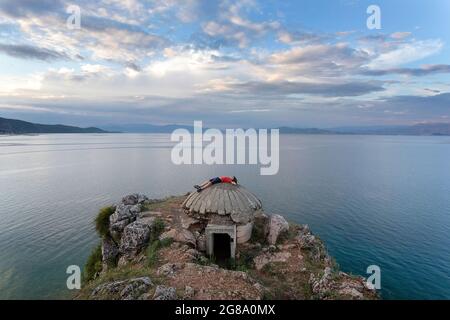 Junge liegt auf einem alten Bunker am Ohridsee, in der Nähe von Lin, Region Korca, Albanien Stockfoto