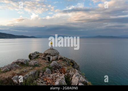 Junge, der auf einem alten Bunker am Ohridsee in der Nähe von Lin, Region Korca, Albanien, steht Stockfoto