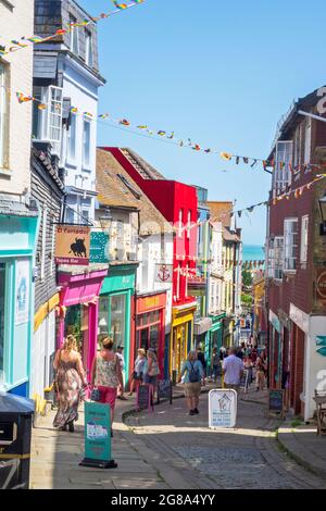 Folkestone, farbenfrohe Geschäfte und Cafés säumen die steile und gepflasterte Old High Street im Creative Quarter, Kent, Großbritannien Stockfoto