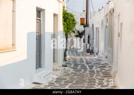 Kykladen. Paros, Griechenland. Weiß getünchte Gebäude, enge gepflasterte Gasse und Treppen. Naousa Dorf traditionelle Architektur in weiß und blau Stockfoto