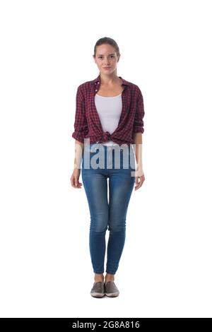 Lässige blonde Frau, die in Jeans und kariertem Hemd vor weißem Hintergrund steht Stockfoto