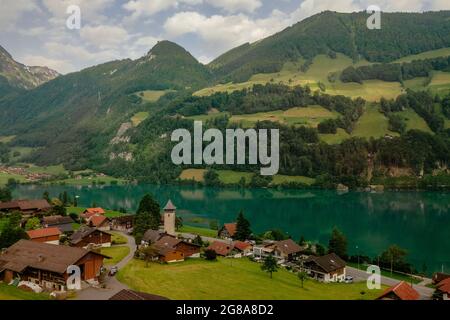 Schweizer Dorf Lungern mit seinen traditionellen Häusern und alten Kirchturm Alter Kirchturm entlang der wunderschönen smaragdgrünen See Firma Lungerersee, Kanton Obwalden Stockfoto