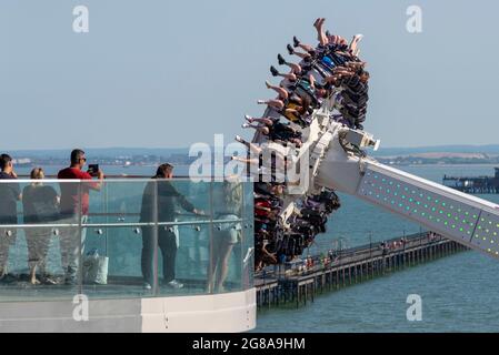 Menschen auf dem Aussichtsterrasse beobachten Thrill Riders auf der Axis Ride in Adventure Island, über Southend Pier, in Southend on Sea, Essex. Hohe Ansicht Stockfoto