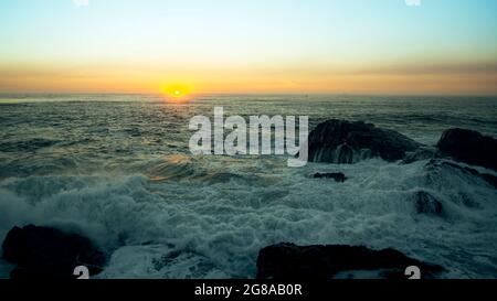 Blick auf die Brandung während eines atemberaubenden Sonnenuntergangs. Stockfoto