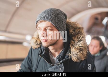 Junger Mann auf der Rolltreppe in der U-Bahn Stockfoto