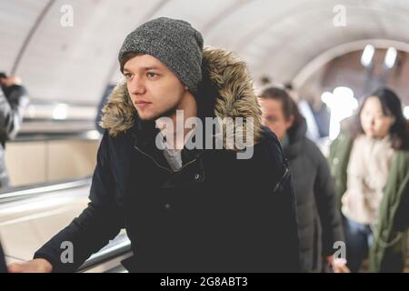 Junger Mann auf der Rolltreppe in der U-Bahn Stockfoto