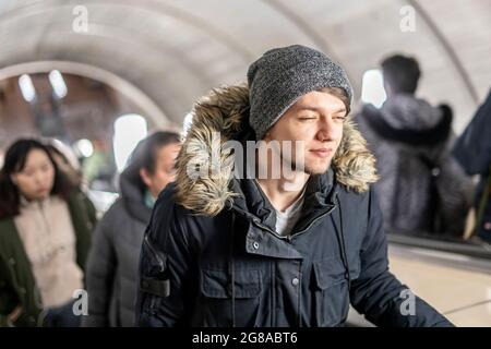 Junger Mann auf der Rolltreppe in der U-Bahn Stockfoto