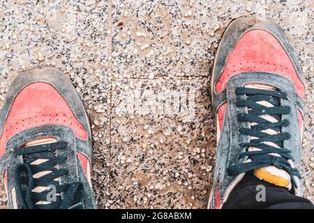 Beschädigte Personenschuhe auf gesalzenem Bürgersteig in der Stadt während der Wintersaison Stockfoto