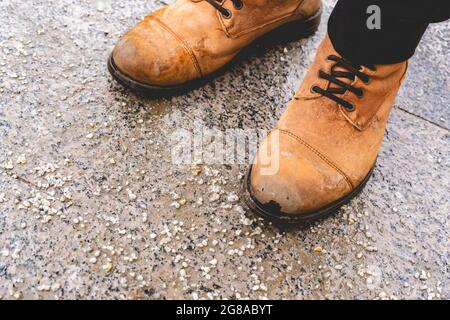 Beschädigte Personenschuhe auf gesalzenem Bürgersteig in der Stadt während der Wintersaison Stockfoto