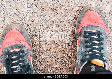 Beschädigte Personenschuhe auf gesalzenem Bürgersteig in der Stadt während der Wintersaison Stockfoto