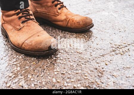 Beschädigte Personenschuhe auf gesalzenem Bürgersteig in der Stadt während der Wintersaison Stockfoto