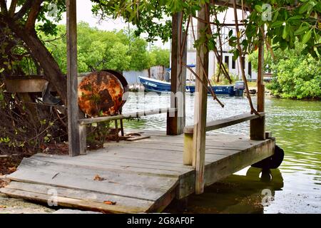 Blick auf einen überdachten Dock, ein Boot und ein Gebäude im Bau auf der Lagunenseite von San Pedro, Belize Stockfoto