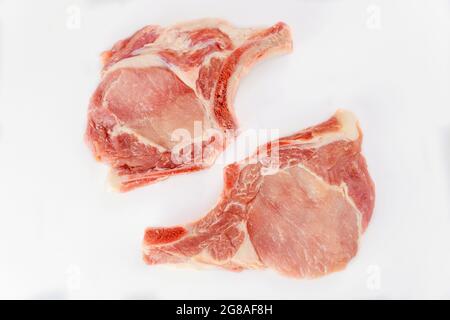 Zwei Stücke roher Schweinekoteletts in Isoladet auf weißem Hintergrund. Draufsicht. Stockfoto