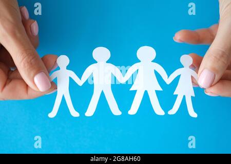 Weibliche Hände zeigen Familie von Papierfiguren Nahaufnahme Stockfoto