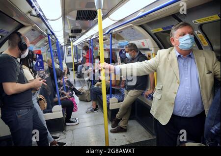 London, Großbritannien. Mai 2021. Passagiere in der Londoner U-Bahn tragen Gesichtsbezüge und respektieren die von der Regierung erlassenen Regeln zur sozialen Distanzierung während der vorgeschriebenen Restriktionen von 19. Nach mehr als einem Jahr der Einschränkungen für das obligatorische Tragen von Gesichtsmasken und die soziale Distanzierung von Reisenden endet (Montag, 19. Juli). Die Regierung hat immer noch das Tragen von Gesichtsmasken empfohlen und zusätzlichen Platz in überfüllten Räumen in Innenräumen ermöglicht. Kredit: SOPA Images Limited/Alamy Live Nachrichten Stockfoto