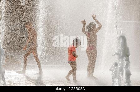 Silhouetten von Kindern, die in einem Wasserbrunnen spielen, im Sommer, Park von Sankt-Petersburg 300 Jahre, Russland Stockfoto