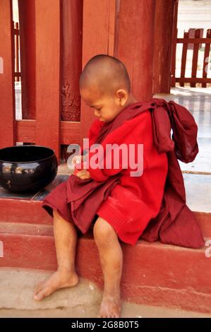 Burmesischer Anfänger, der Geld spielt, um Spenden von burma-Leuten und ausländischen Reisenden zu erhalten, besuchen Respect Praying am Shwezigon Pagoda Paya Tempel in Bagan Stockfoto