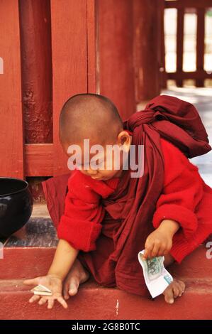 Burmesischer Anfänger, der Geld spielt, um Spenden von burma-Leuten und ausländischen Reisenden zu erhalten, besuchen Respect Praying am Shwezigon Pagoda Paya Tempel in Bagan Stockfoto