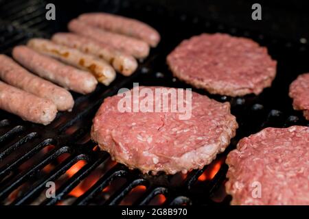 Hamburger auf Grill mit tanzenden Flammen, perfekt zubereitet Stockfoto
